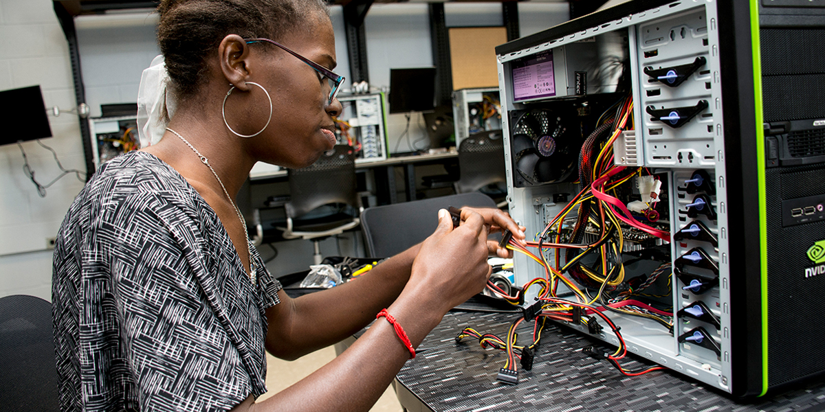 Student working inside a computer tower