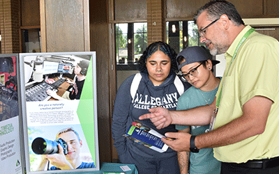 Program Director John Bone chats with students about multimedia program